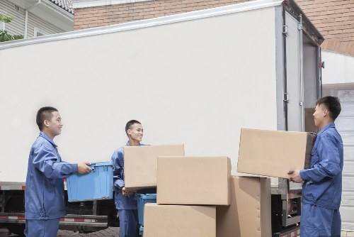 Packed moving boxes and furniture ready for transport in Brent